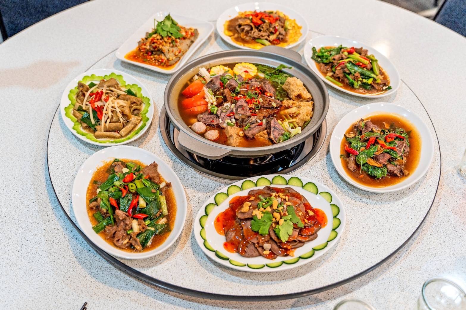 圓桌轉盤擺滿牛肉爐與熱炒合菜，聚餐圍爐熱鬧上桌