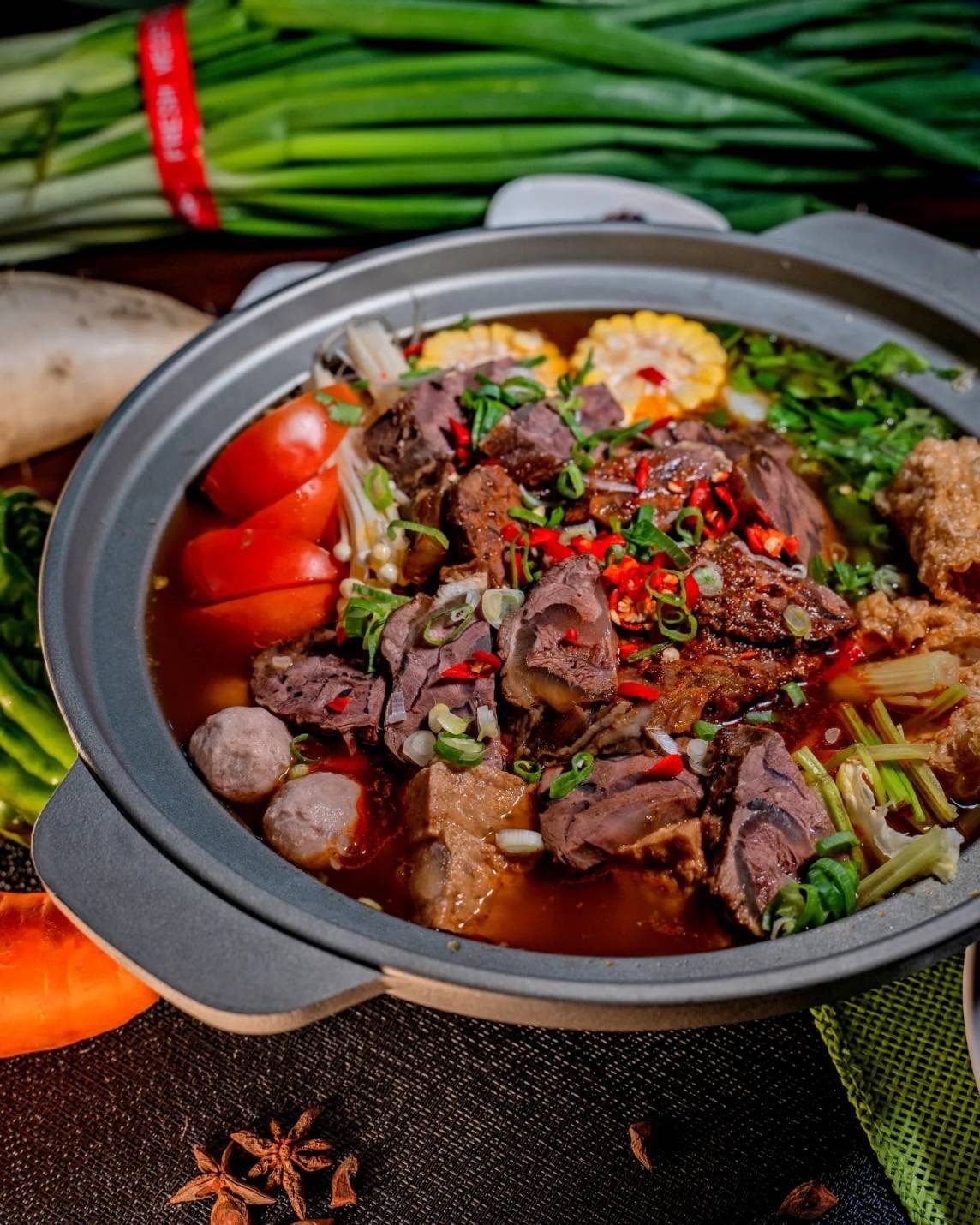 招牌牛肉爐湯頭滾沸,鮮切牛肉、番茄與玉米熱氣蒸騰